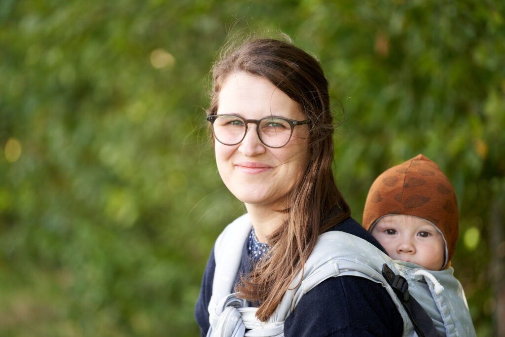 Baby wird auf dem Rücken getragen in der Tragehilfe