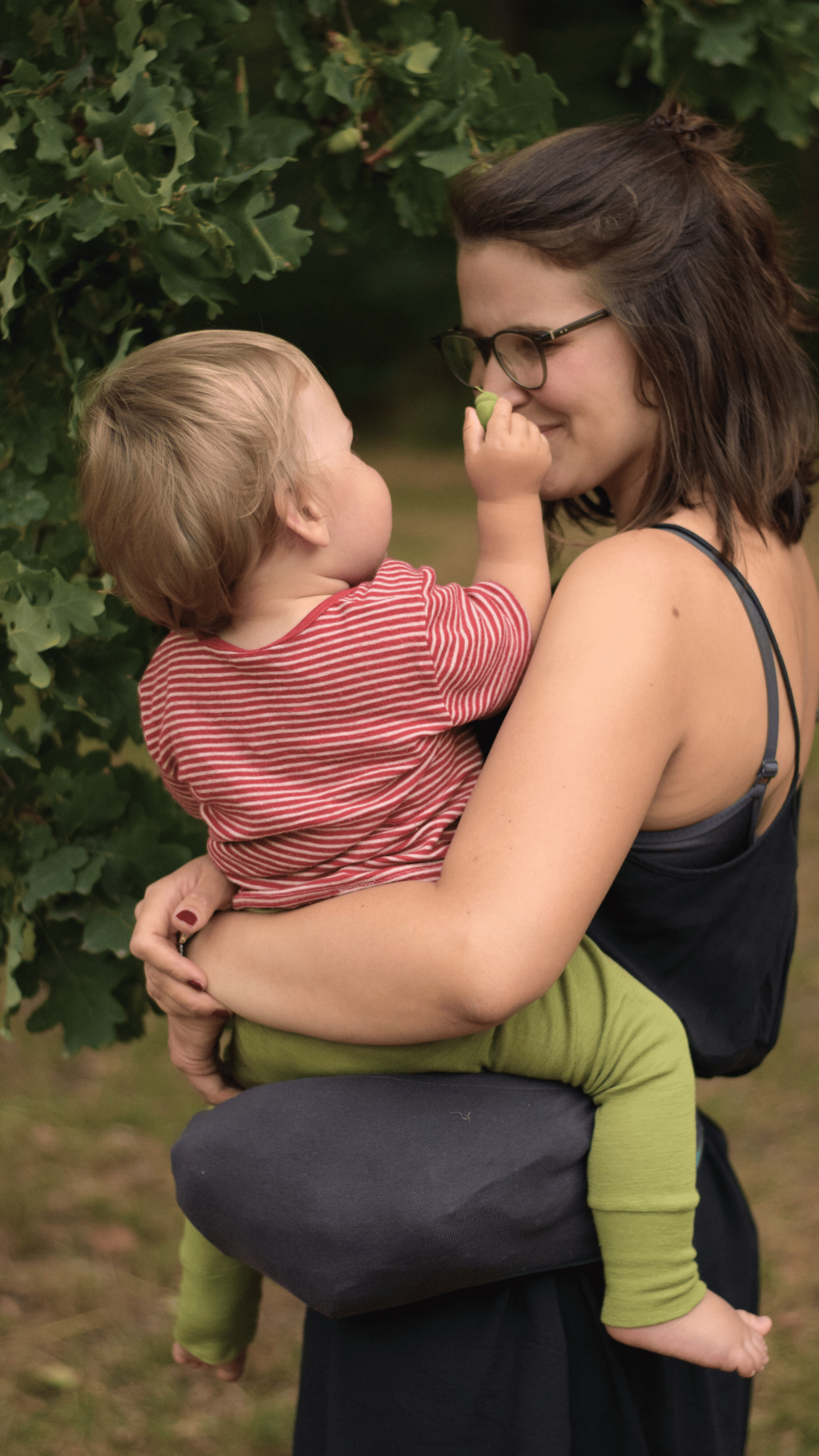 eine Mutter trägt ihr Kleinkind auf der Hüfte