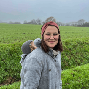 Mama mit Baby in der Trage und Tragejacke